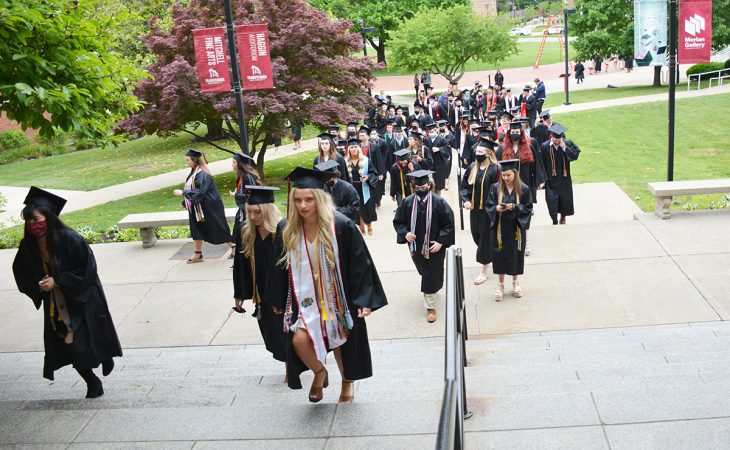graduates walking up steps