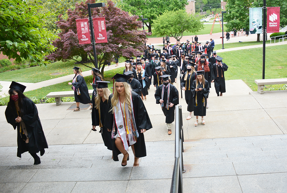 graduates walking up steps