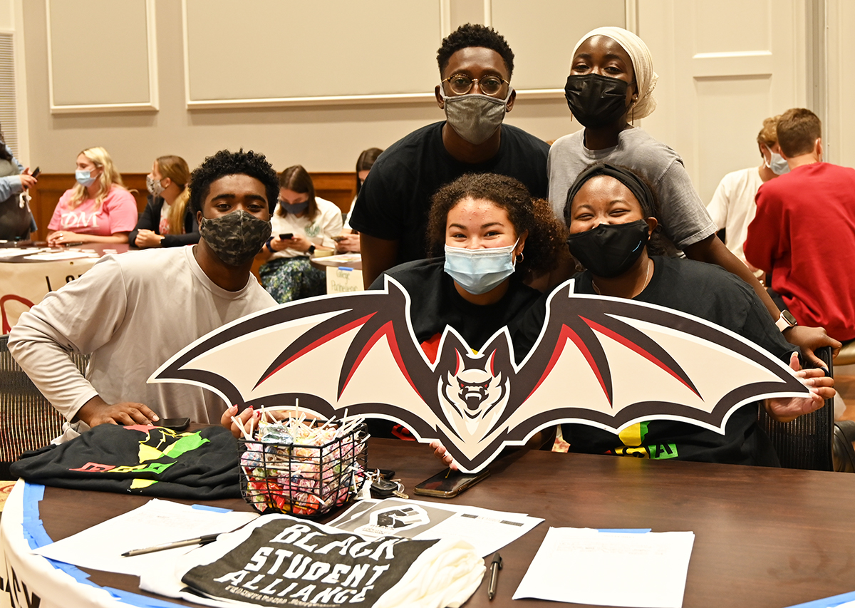 students at a table with a bat