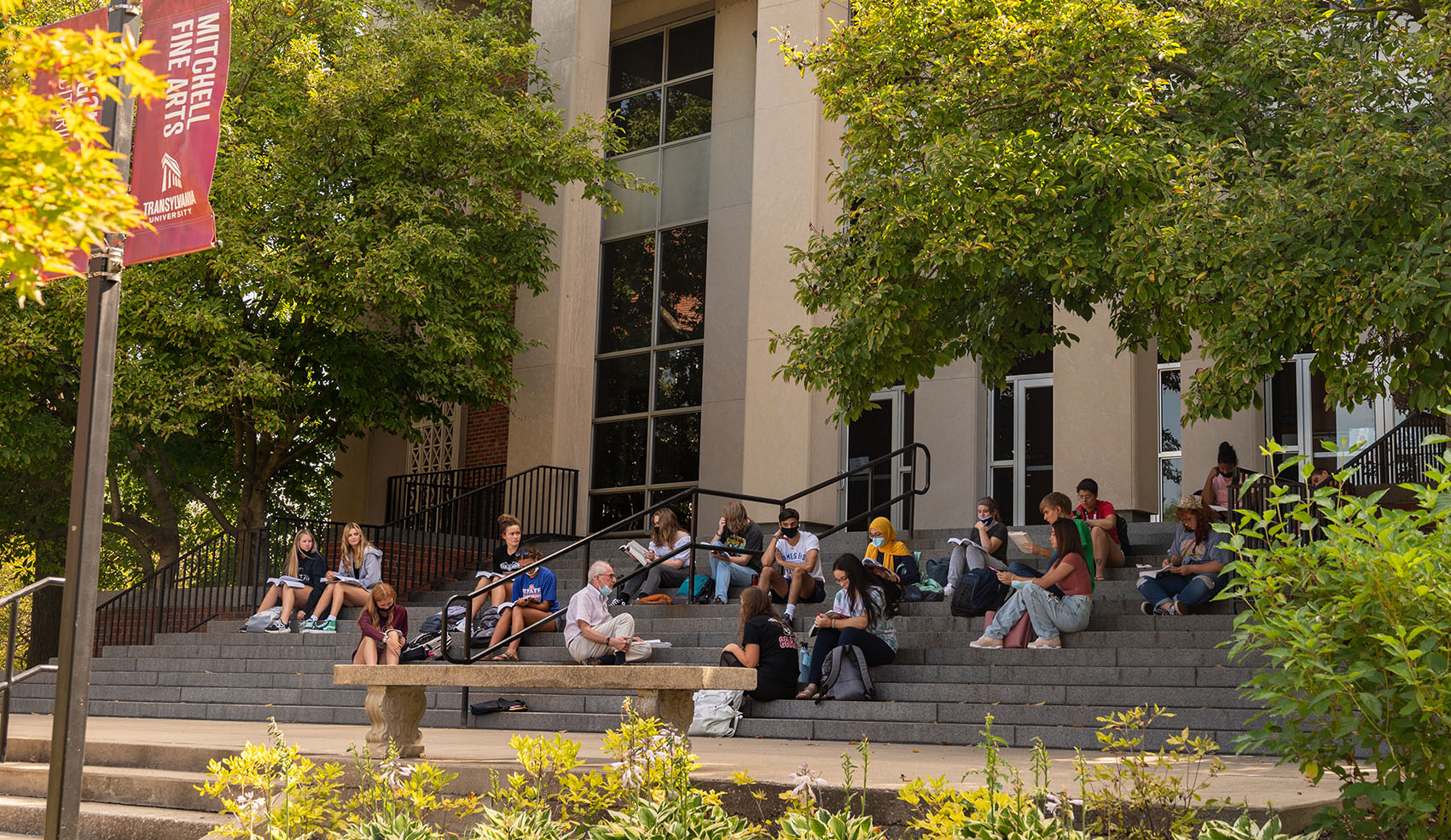 Students seated on the steps of the Mitchell Fine Arts Center at Transylvania