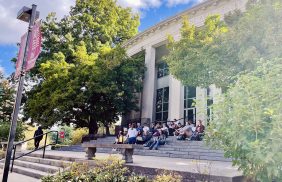 Students seated on the front steps of Mitchell Fine Arts Center
