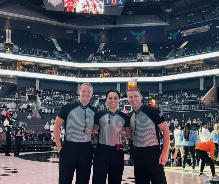 Molly Caldwell and two other referees at a college basketball game. 