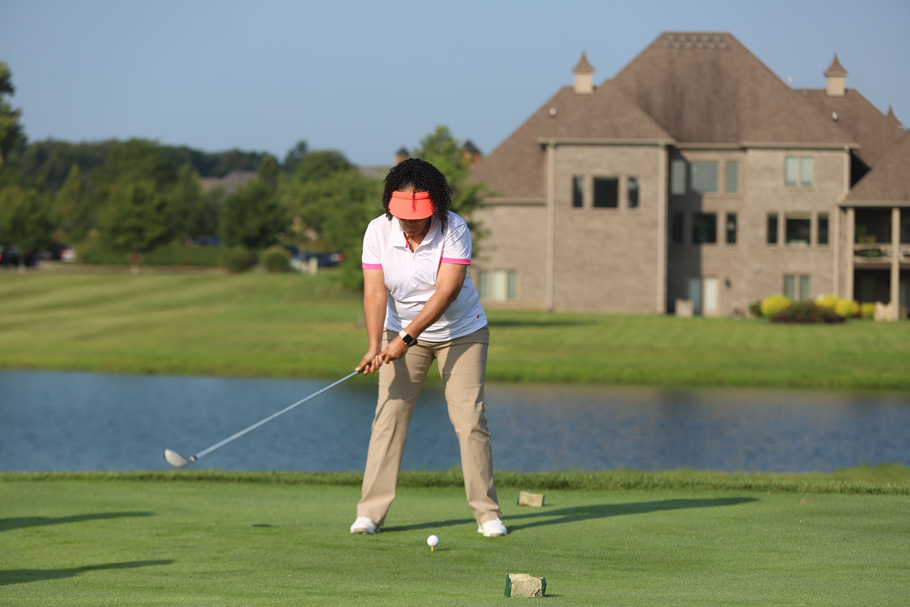 A golfer swinging at a golf ball.