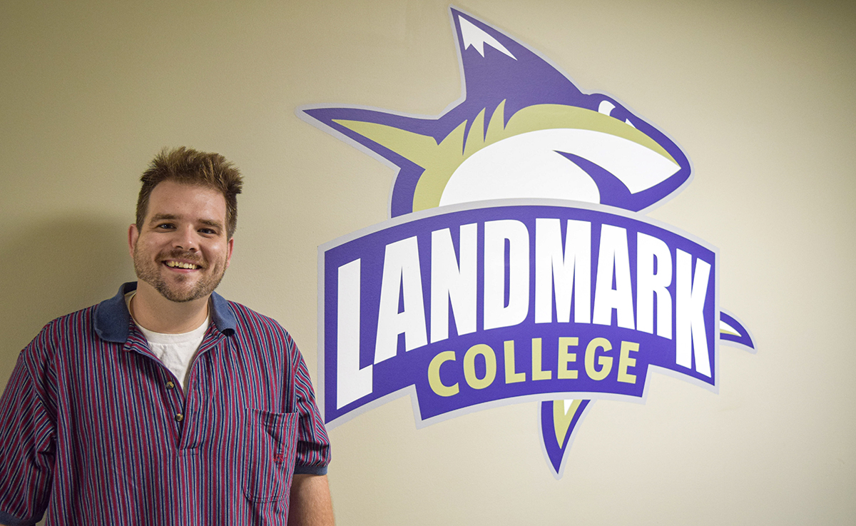 person standing in front of a college logo