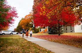 Students walk in front of Old Morrison in the autumn.