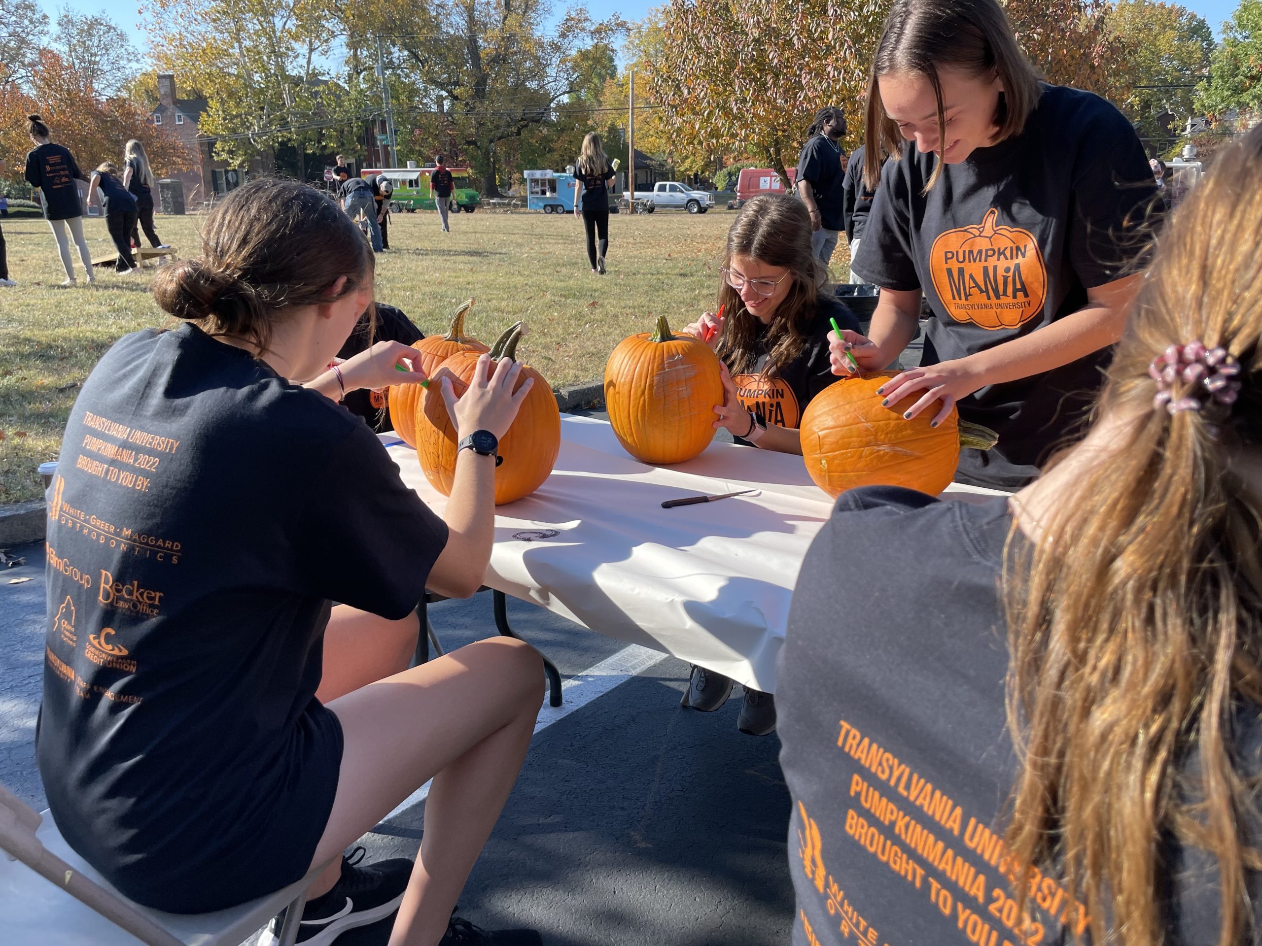 Students carving pumpkins at the 2022 PumpkinMania event.