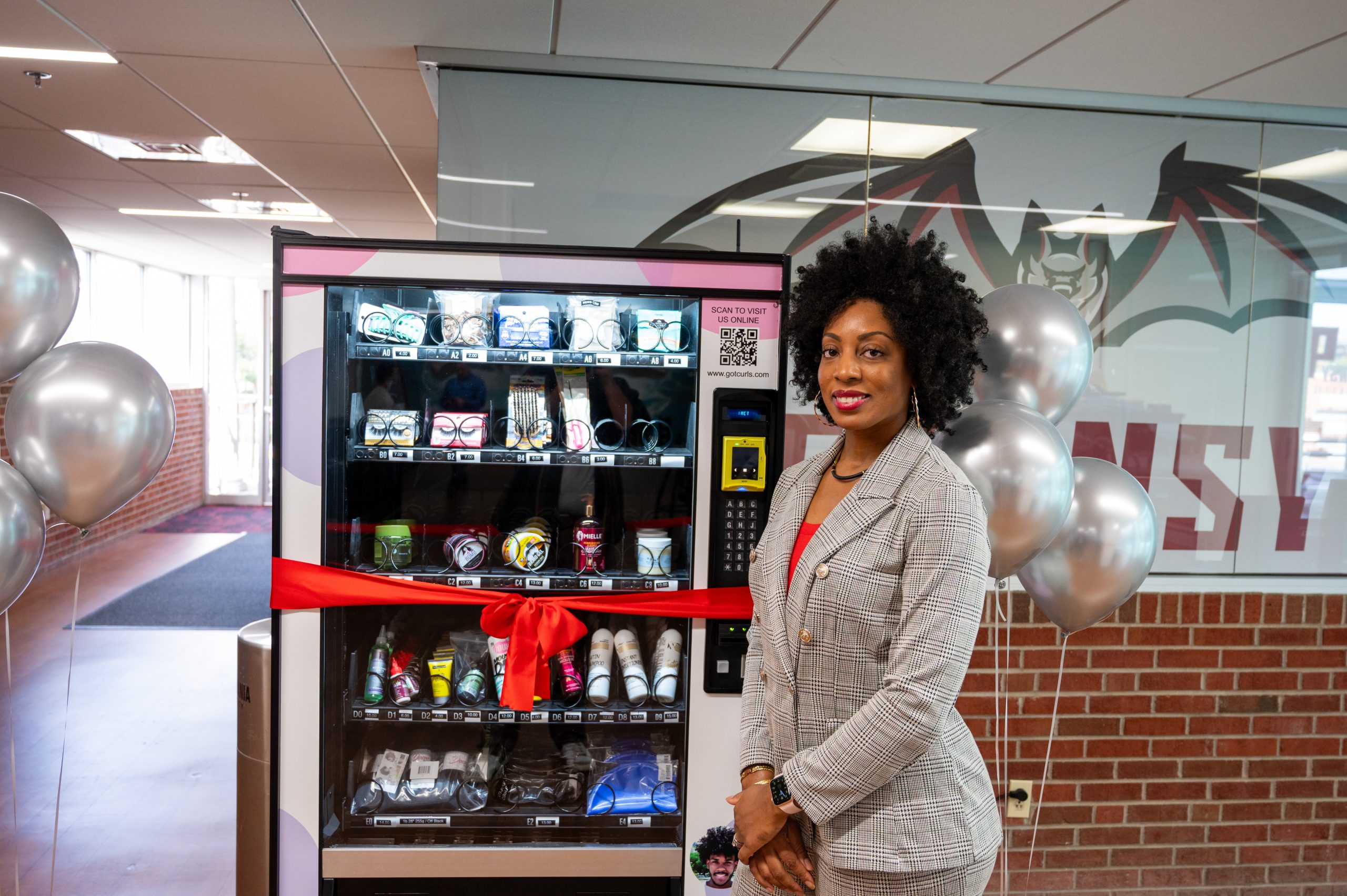 Melanie Day stands next to the new beauty vending machine in the Campus Center.