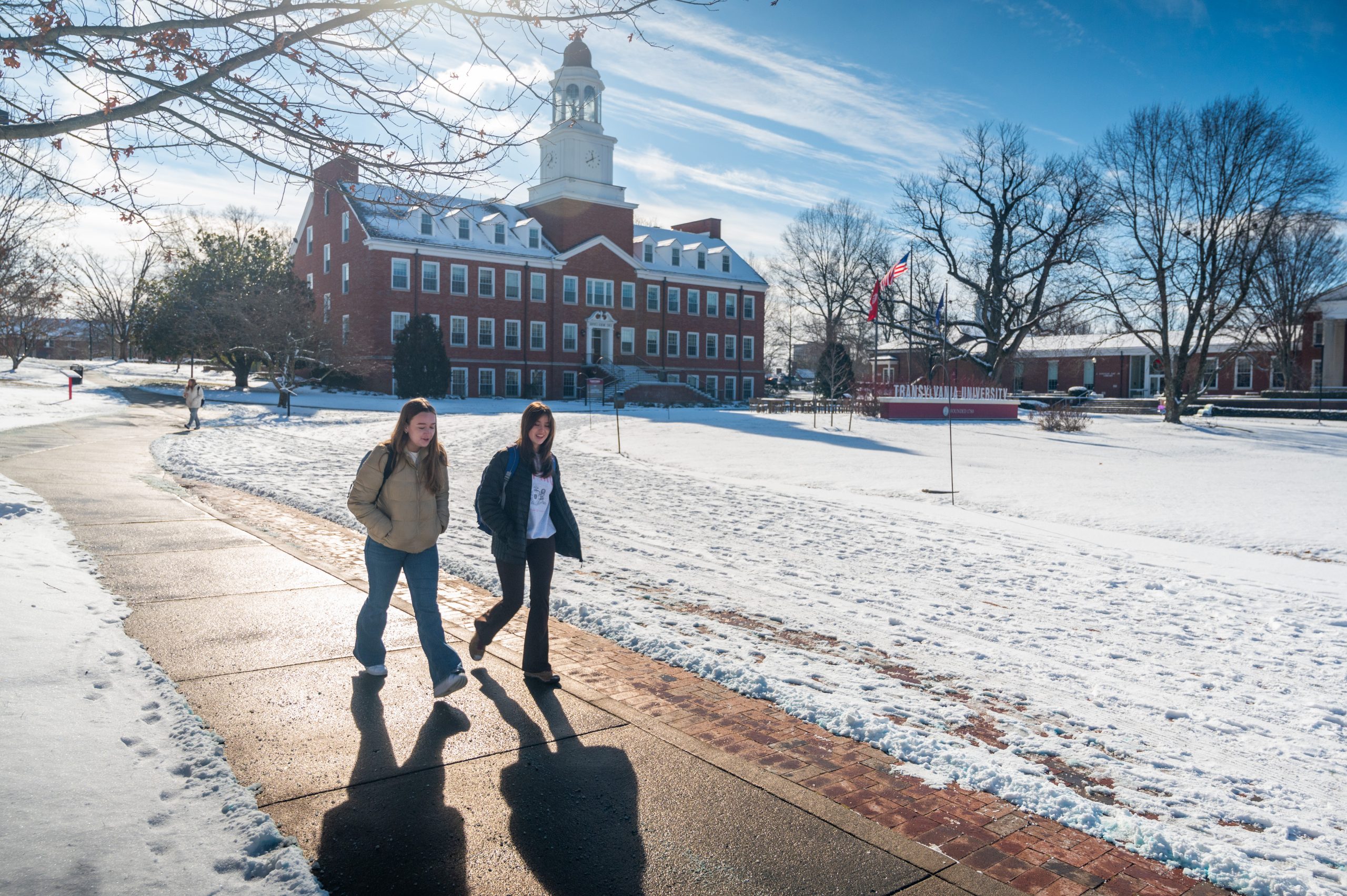 Students walking on campus on a snowy day.