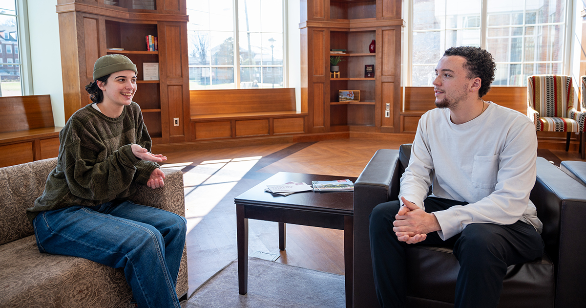 two people in chairs talking to each another