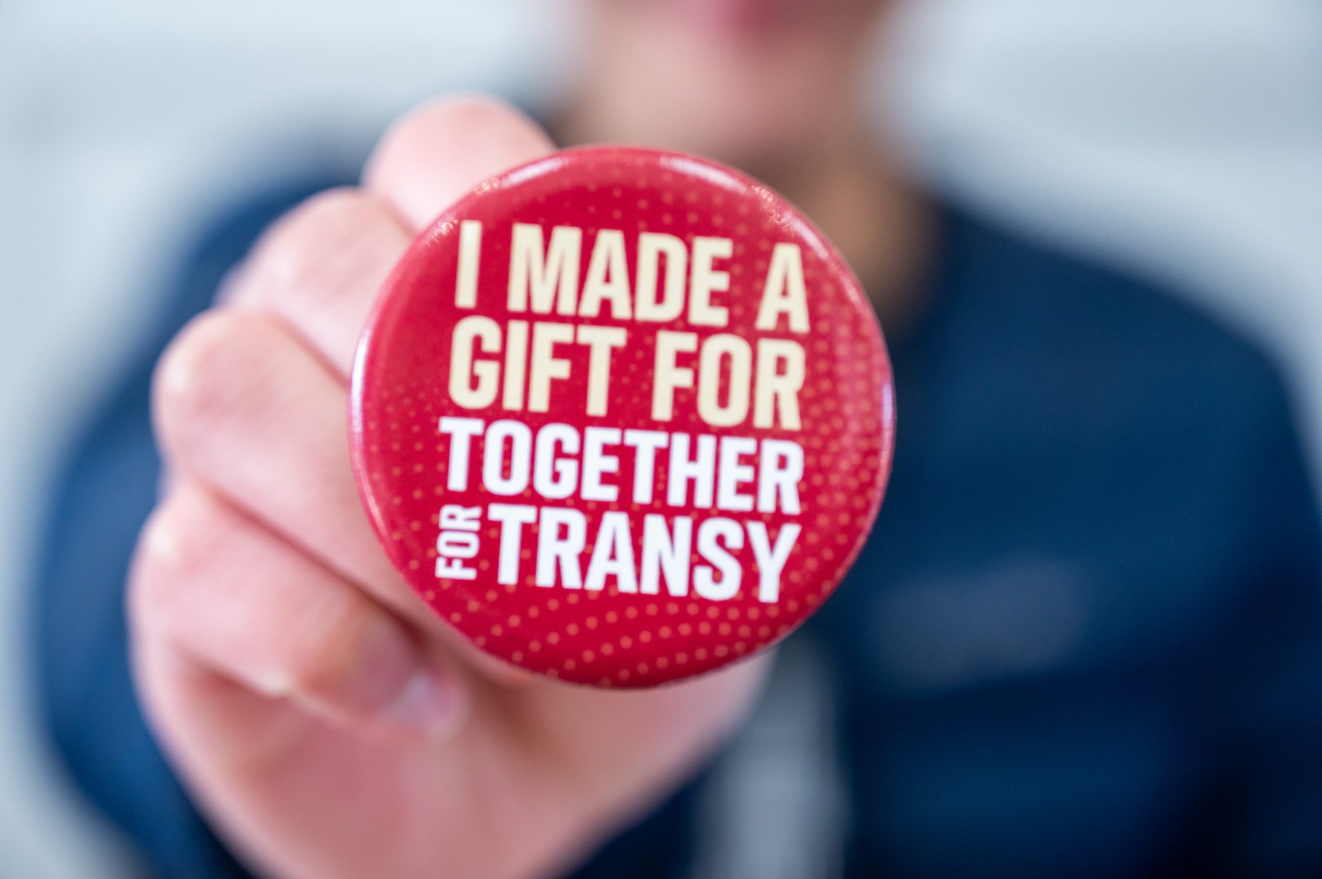 Donor holding a button that reads "I made a gift for Together for Transy."