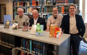 authors standing in front of books