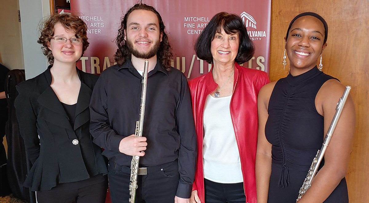four people posing, two with flutes