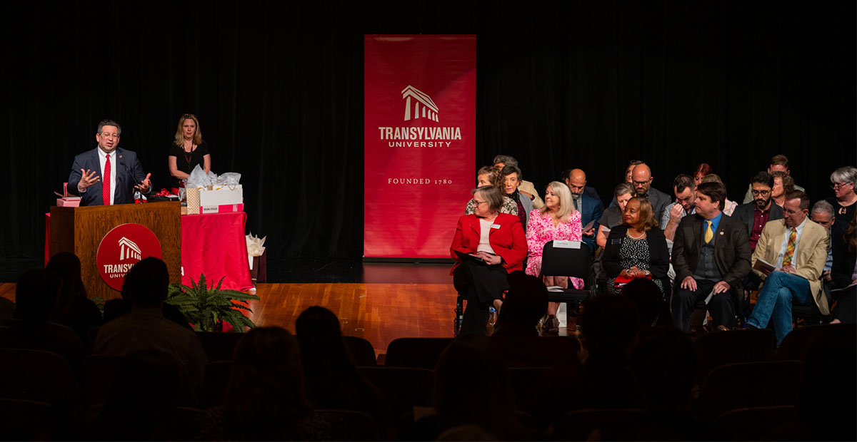 people sitting on stage and presenting