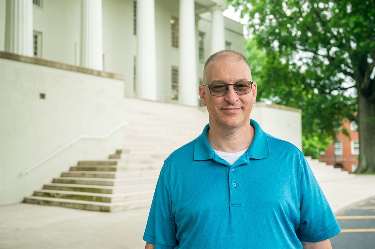 man standing in front of a campus building