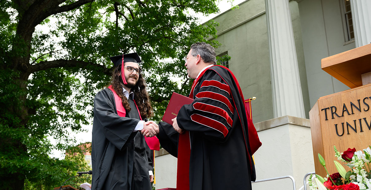 person getting a diploma and shaking hands