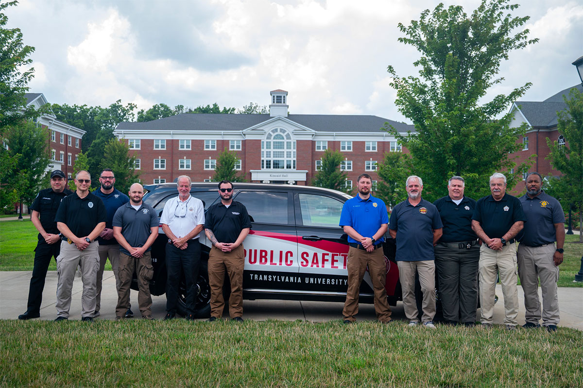 police officers standing around a squad vehicle