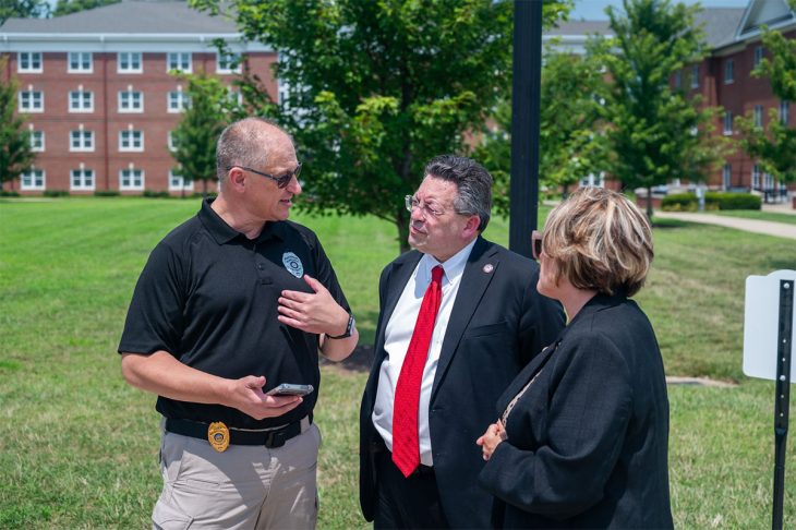 three people talking outdoors