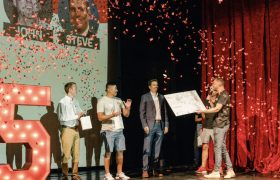 people on stage with confetti getting an award