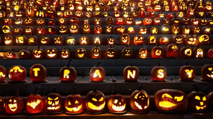 dozens of lit jack-o'-lanterns