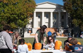 people carving pumpkins at a table