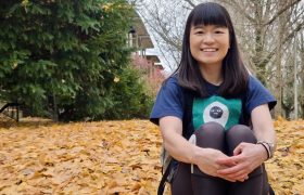 a person sitting on a leaf covered lawn