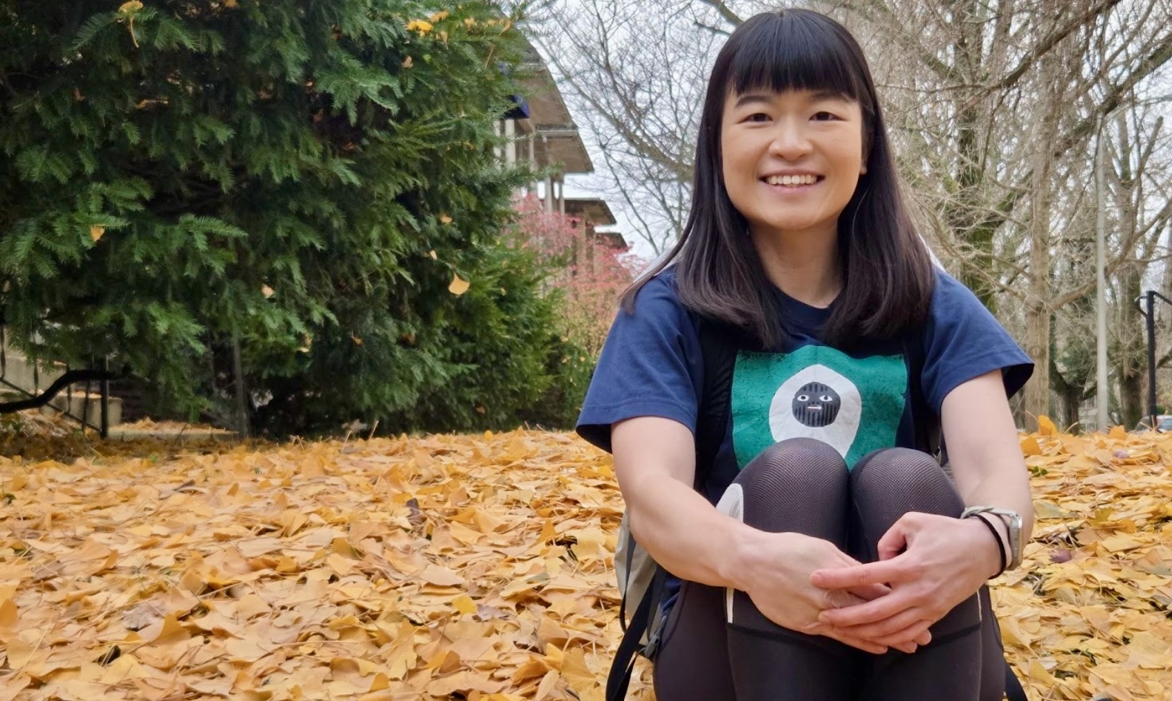 a person sitting on a leaf covered lawn