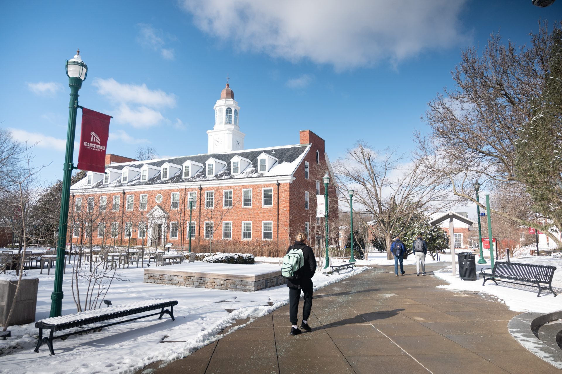 students walking across a snowy campus