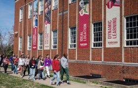 people walking in front of a campus building
