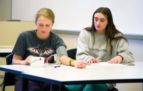 two students, one getting her blood pressure taken