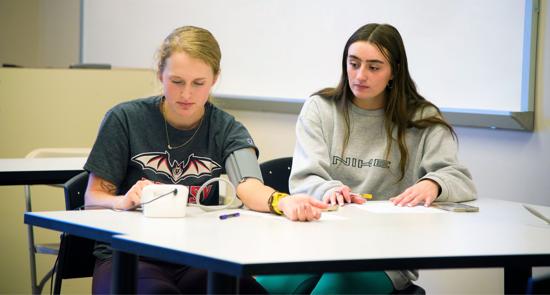 two students, one getting her blood pressure taken