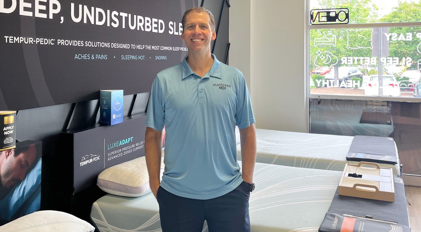 a man standing in a mattress store