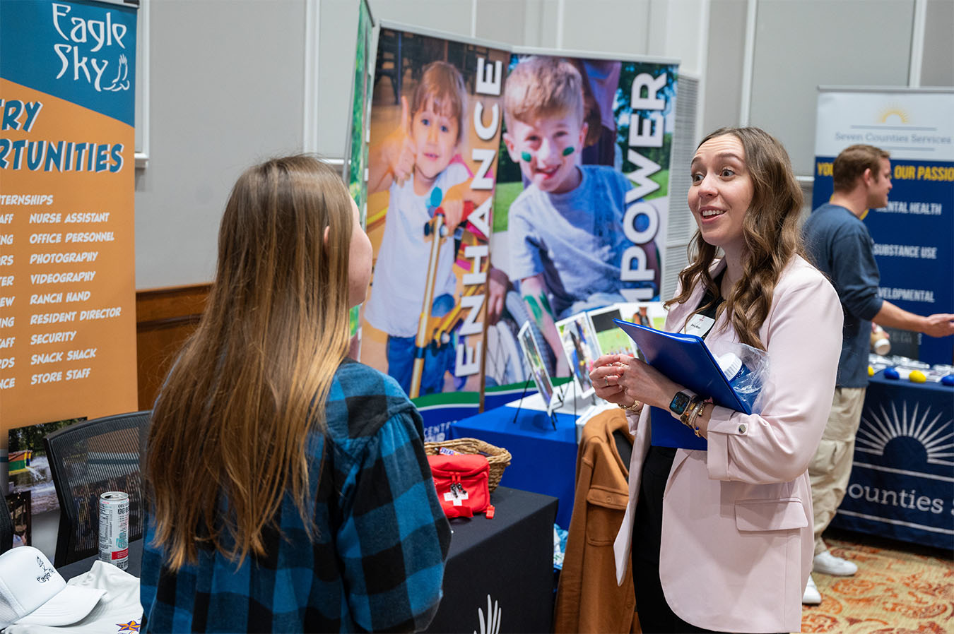people chatting at an info booth