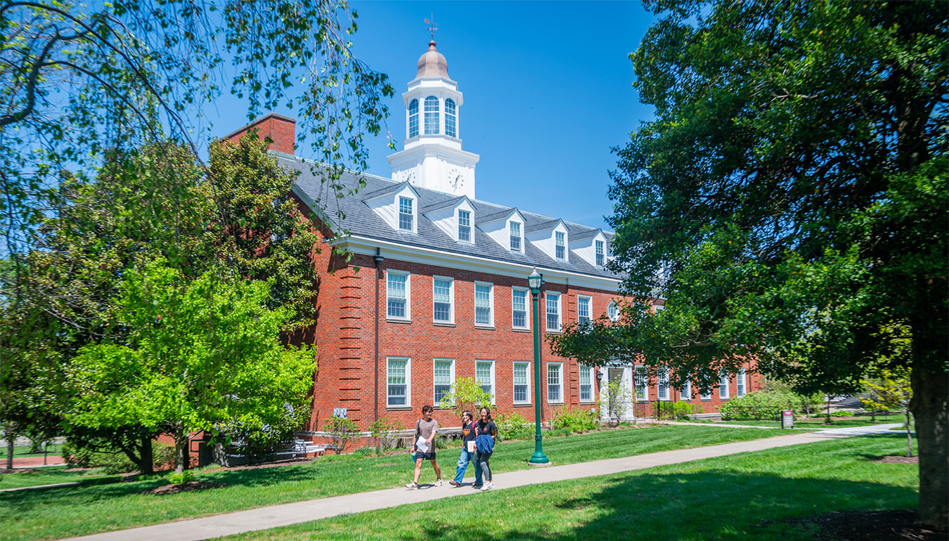 students walking in front of a campus building