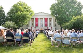 people on a lawn watching commencement