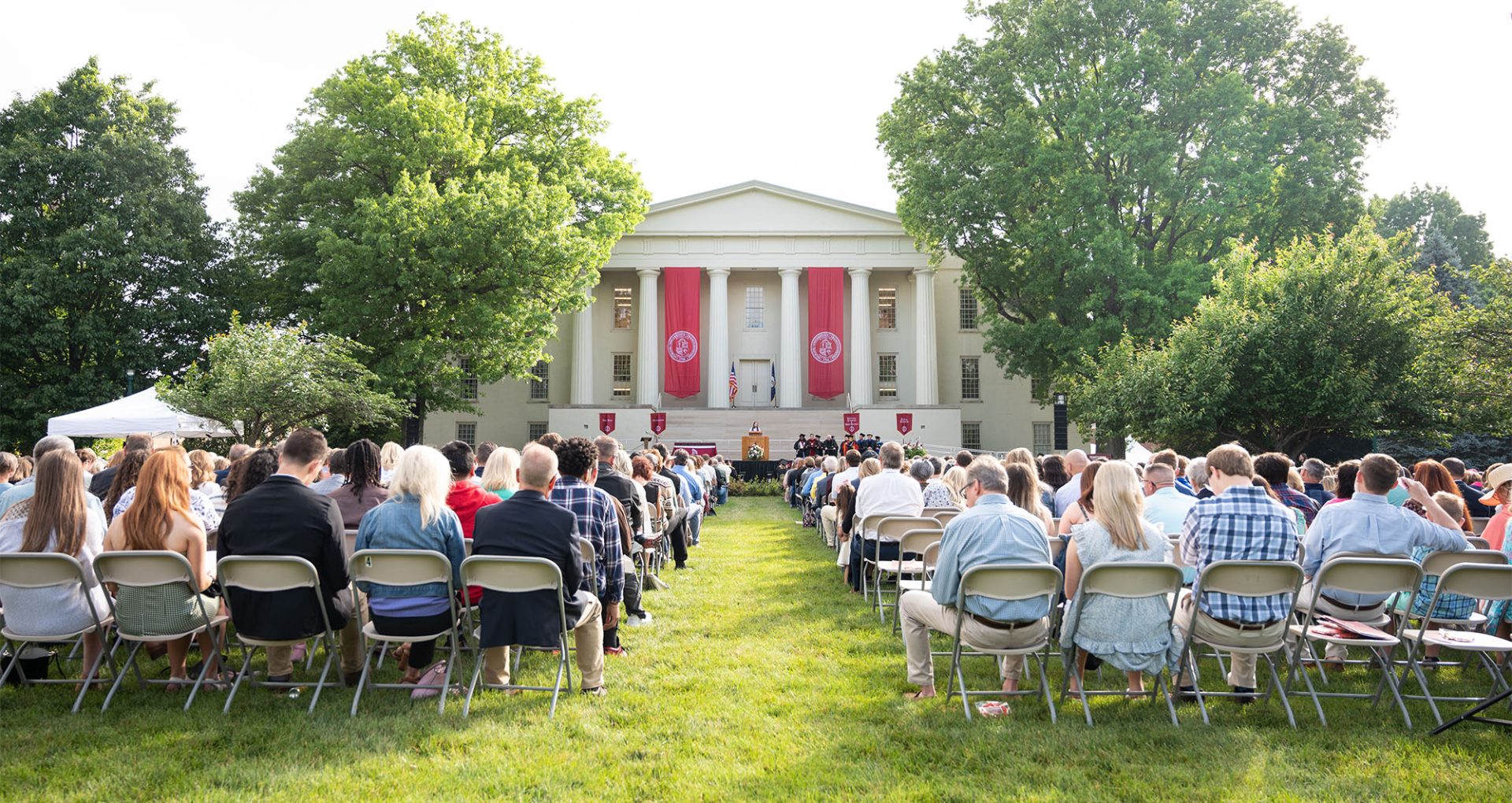people on a lawn watching commencement