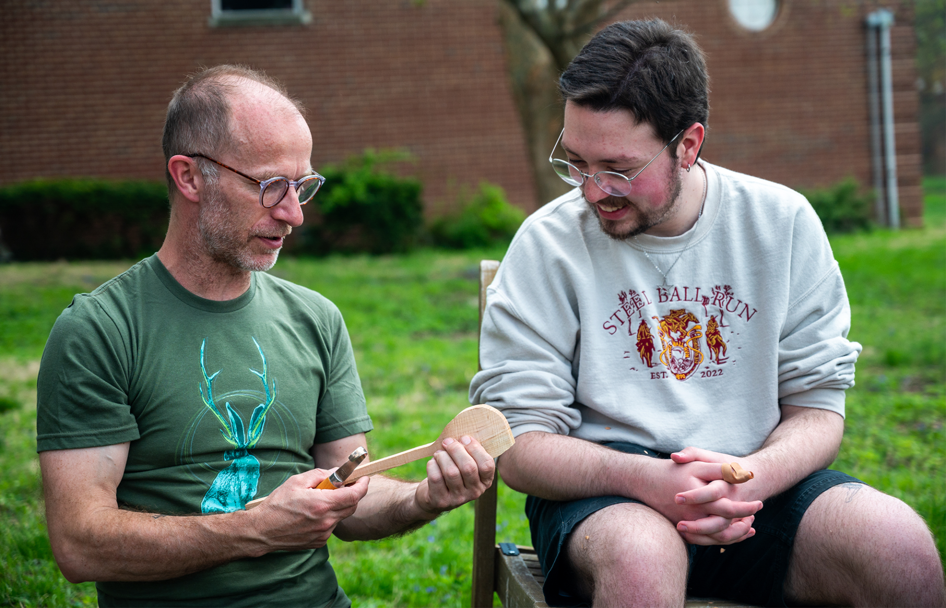 people looking at a carved spoon