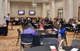 people watching a presentation in a large room