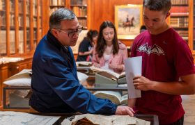 professor and students looking at old books