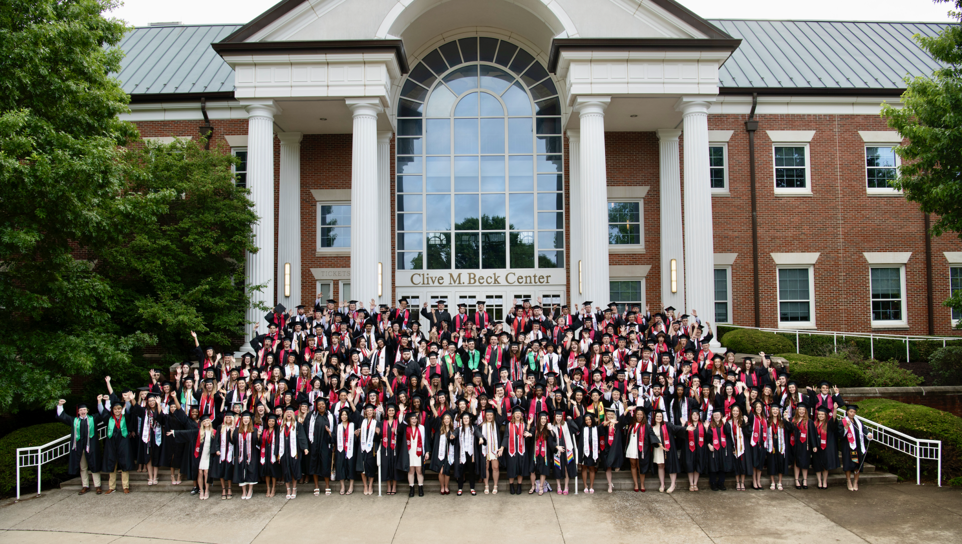 senior class posing in front of a campus building