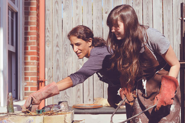 Zoe Strecker & student wearing work gloves and using tongs.