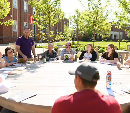 classes, such as this one being taught at an outdoor table, are a key component of academic life at transy