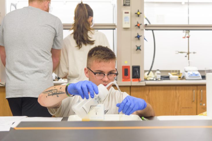 student measuring fluid in a science lab