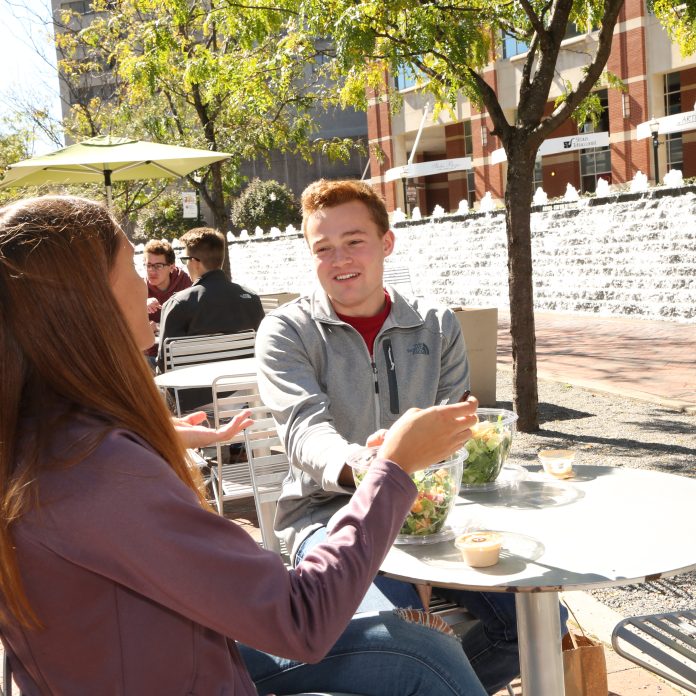 students sitting at a table in lexington's triangle park