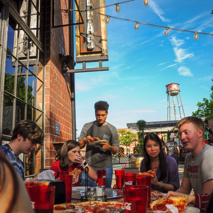 students dining outdoors in lexington, eating pizza
