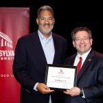 Erwin Roberts holding award with Brien Lewis