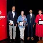 alumni holding framed awards