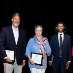 alumni holding framed awards