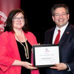 Shannan Stamper holding award with Brien Lewis