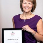 Portrait of Danielle Tharp Clore holding award