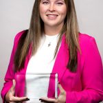 portrait of woman in pink holding award